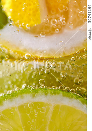 Ripe sliced pieces of lemon and lime in a glass with water and bubbles. Macro photo of summer 50741194