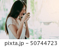 Young pretty woman enjoying a cup of coffee 50744723