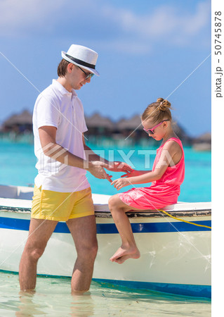 Little girl and dad on boat during tropical beach vacation Little girl and dad on boat during tropical beach vacation 50745878