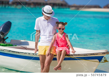 Happpy father and daughter on boat during tropical beach vacation Happpy father and daughter on boat during tropical beach vacation 50745879