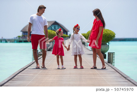 Beautiful family have fun on wooden jetty during summer vacation  50745970