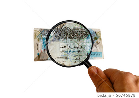one Qatar Riyal bill and magnifying glass in hand one Qatar Riyal bill and magnifying glass in hand 50745979