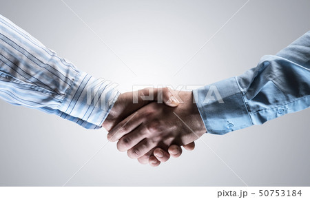 Business handshake as idea for unity and cooperation or greeting. Mixed media Business handshake as idea for unity and cooperation or greeting. Mixed media 50753184
