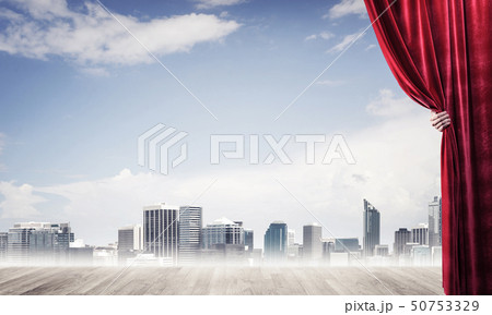 Business city in gray fog behind red curtain and hand holding it Business city in gray fog behind red curtain and hand holding it 50753329