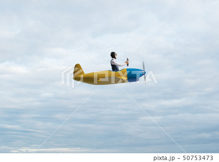 Man in aviator hat driving propeller plane 50753473