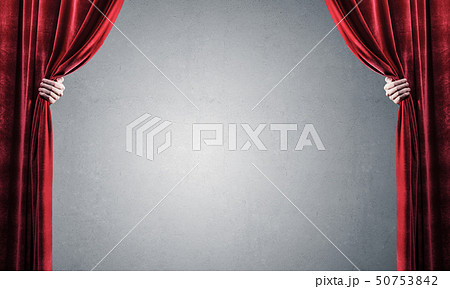 Concrete wall behind drapery curtain and hand opening it Concrete wall behind drapery curtain and hand opening it 50753842