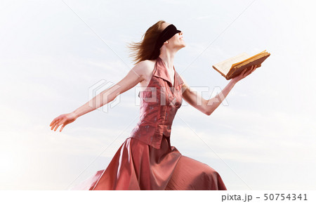 Girl against cloudy sky with opened book in palm as idea for knowledge 50754341