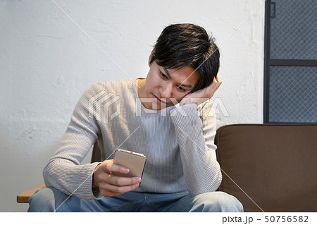 スマートフォンを手に考え込む男性 スマートフォンを手に考え込む男性 50756582