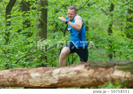Young sporty man running trail cross in the forest Young sporty man running trail cross in the forest 50758551