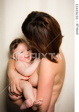 A young naked mother holds on her hands a wonderful nude baby A young naked mother holds on her hands a wonderful nude baby 50763453