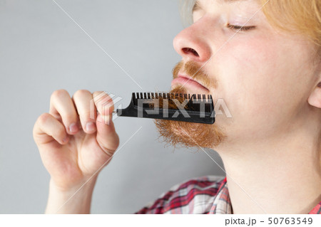 Man combing his beard 50763549