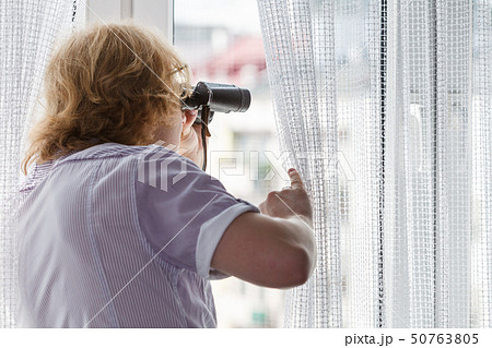 Man with binoculars spying on neighbors Man with binoculars spying on neighbors 50763805
