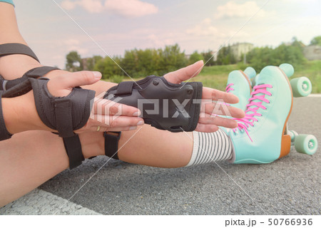 Woman rollerskater wearing wrist guards protector Woman rollerskater wearing wrist guards protector 50766936