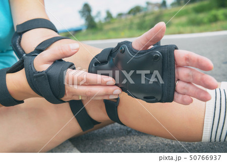 Woman rollerskater wearing wrist guards protector Woman rollerskater wearing wrist guards protector 50766937