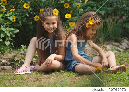 portrait of happy beautiful girls in flowerbed portrait of happy beautiful girls in flowerbed 50769070