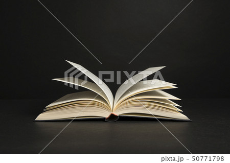 Open book with pages on a black background 50771798