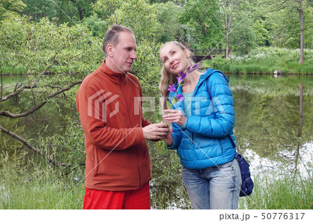 man on a date gives  woman a bell flower in the su 50776317