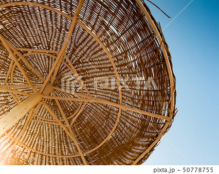 Image of straw umbrellas on the ocean beach at hot sunny day against blue sky Image of straw umbrellas on the ocean beach at hot sunny day against blue sky 50778755
