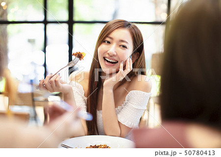 young woman with friends having dinner in the 50780413