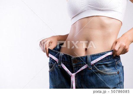 Close up slim young woman measuring her thin waist Close up slim young woman measuring her thin waist 50786085