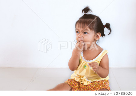 baby asian child girl eating noodle by herself  50788020