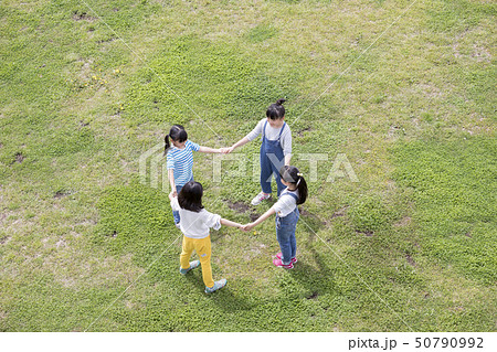 芝生で手を繋いで輪になる子供達 50790992