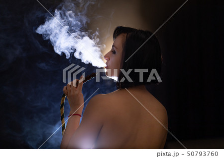 Beautiful, naked woman smoking hookah. Attractive girl smoking flavored tobacco Beautiful, naked woman smoking hookah. Attractive girl smoking flavored tobacco 50793760