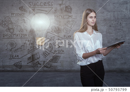 Beautiful business woman against a concrete wall with sketch drawn on it and bright lightbulb Beautiful business woman against a concrete wall with sketch drawn on it and bright lightbulb 50793799