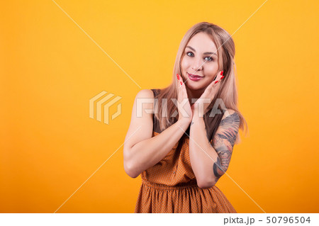 Attractive caucasian woman with a cute face looking at the camera over yellow background 50796504