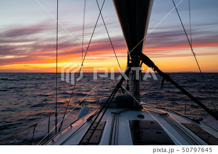 Yacht sailing at sunset during a storm. Luxury vacation at sea Yacht sailing at sunset during a storm. Luxury vacation at sea 50797645