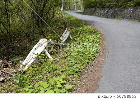 ガードレール 経年劣化で折り曲がり錆びついたまま放置された状態 50798955