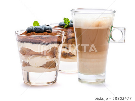 Classic tiramisu dessert with blueberries in a glass and cup of coffee isolated on a white 50802477
