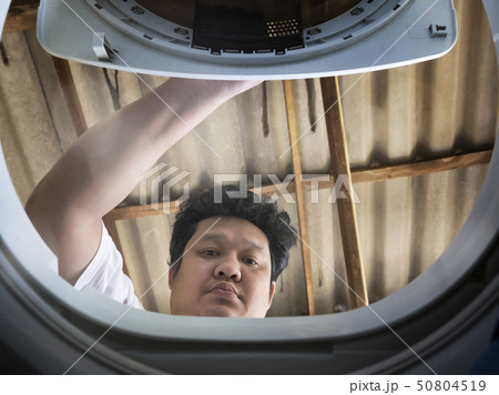 Man open the washing machine door. 50804519