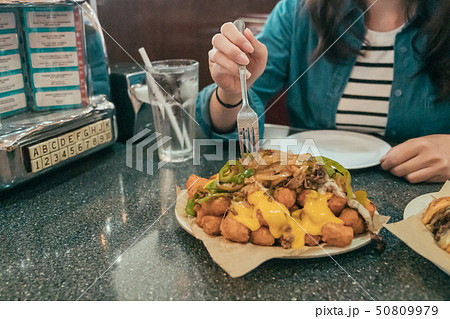 woman eating fast food and drinking soda 50809979