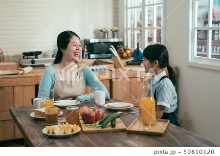 mother with children having breakfast in kitchen 50810120