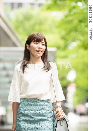 買い物をする若い日本人女性　街路樹　都会 50811696