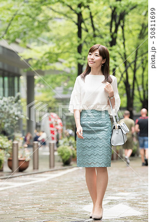 買い物をする若い日本人女性　街路樹　都会 50811699