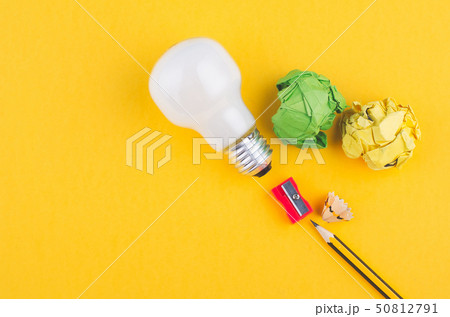 pencil,crumple paper and bulb on yellow background 50812791