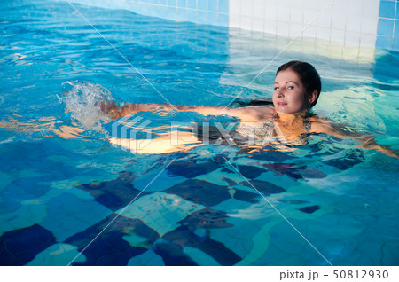 Attractive girl relaxes in swimming pool 50812930