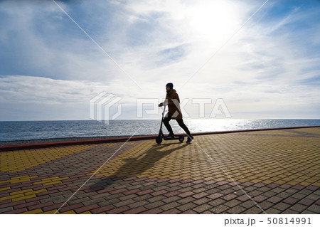 Man on scooter at sunset, silhouette, free space 50814991