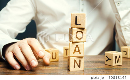 Wooden blocks with the word loan and businessman. 50818145