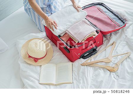 People packed suitcase with travel accessories on People packed suitcase with travel accessories on 50818246
