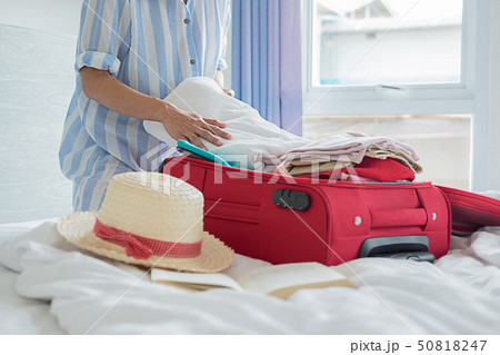 People packed suitcase with travel accessories on 50818247