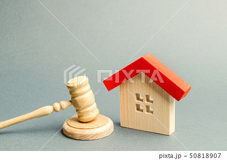 Miniature wooden house and judge's hammer.  50818907