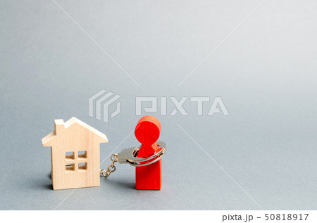 The man is handcuffed to a wooden house.  50818917