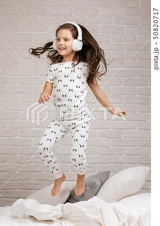 little child girl listening to the music with the headphones 50820717