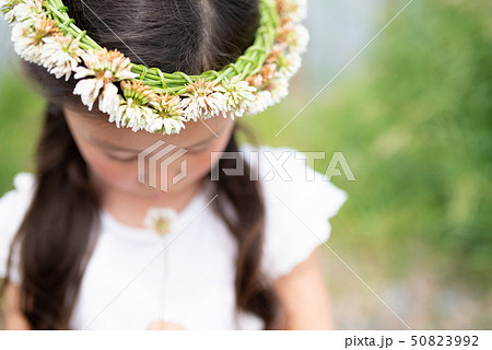 シロツメクサの冠をかぶった女の子の写真素材