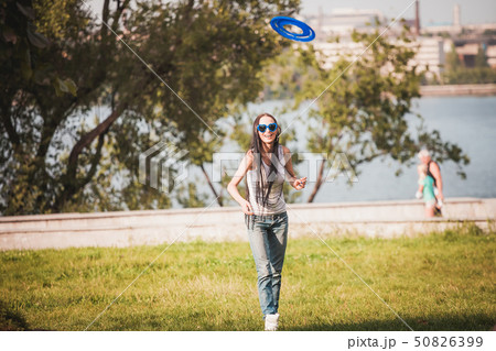 Family playing frisbee on meadow in park 50826399