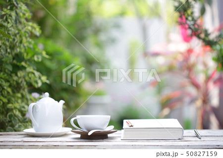 White coffee cup and notebooks on wooden table  50827159