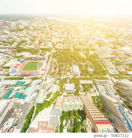Aerial city view with crossroads and roads, houses, buildings, parks and parking lots. Sunny summer 50827212